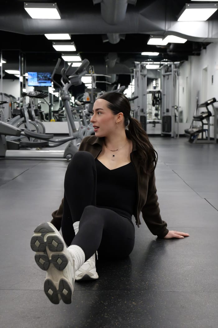 Ena sitting on the gym floor, smiling