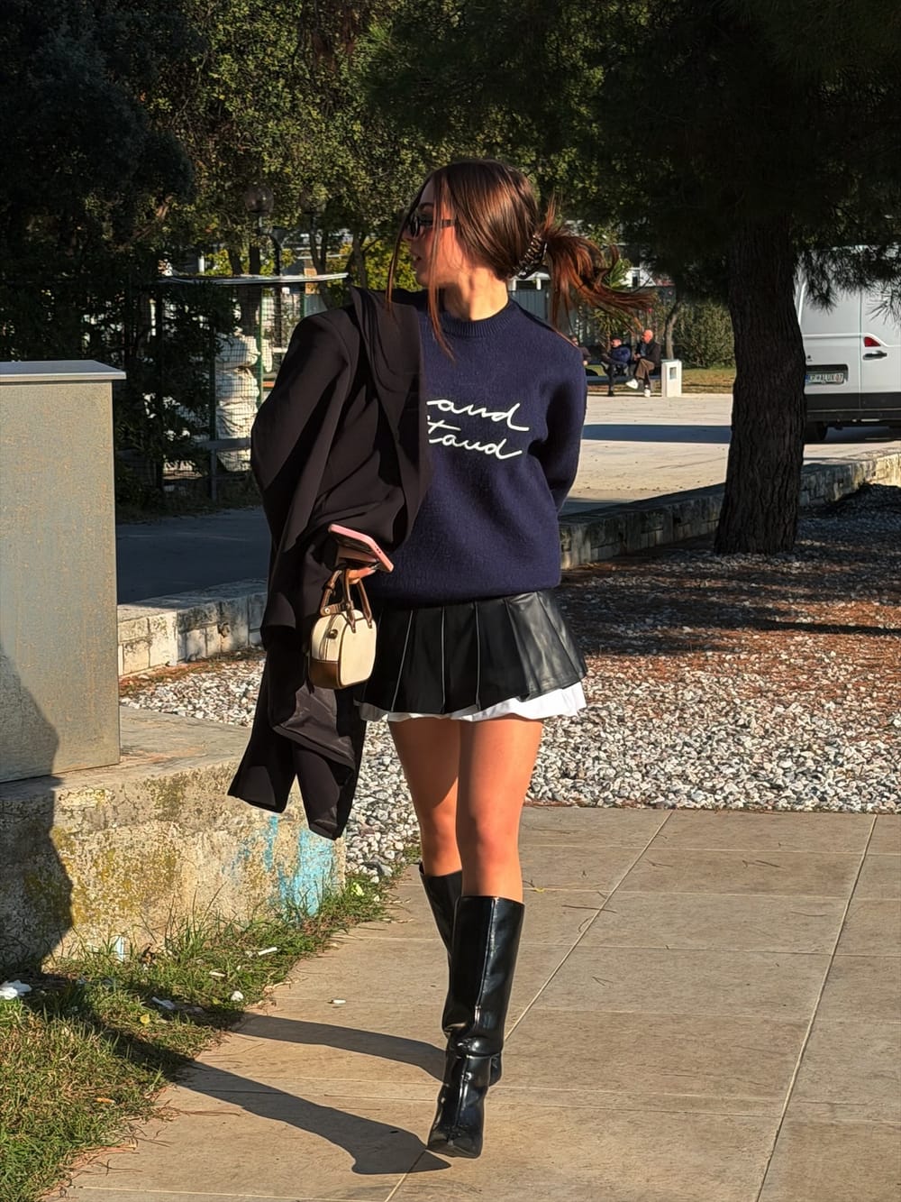 Ena walking outdoors with a blazer over her shoulder