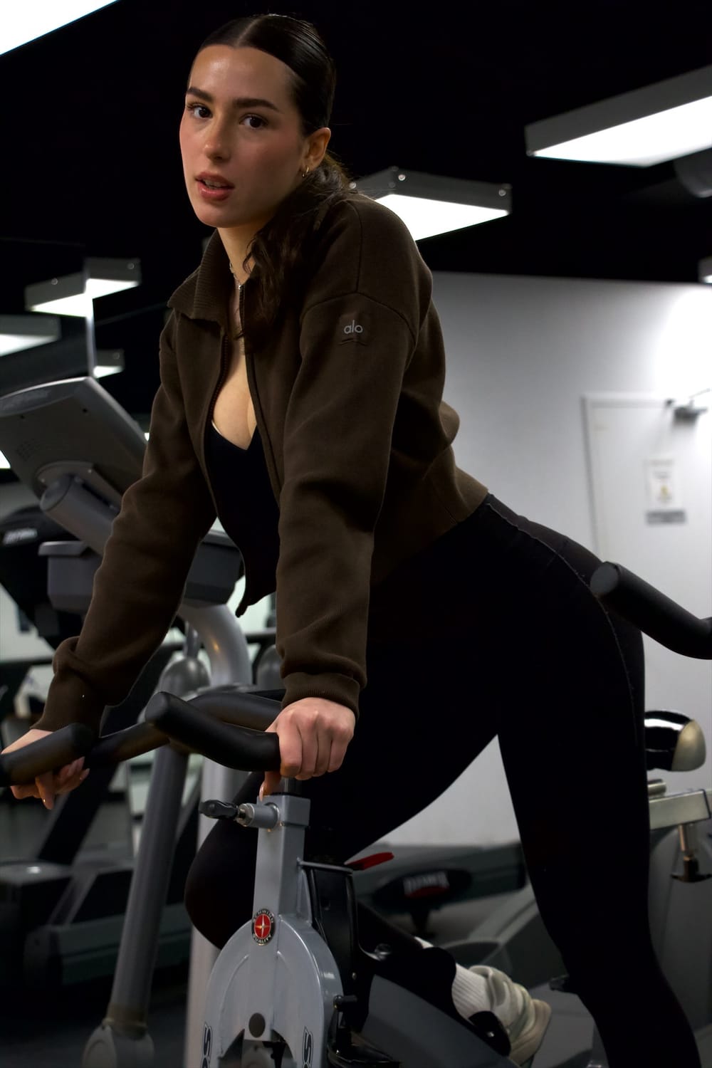 Ena on an exercise bike, looking at the camera